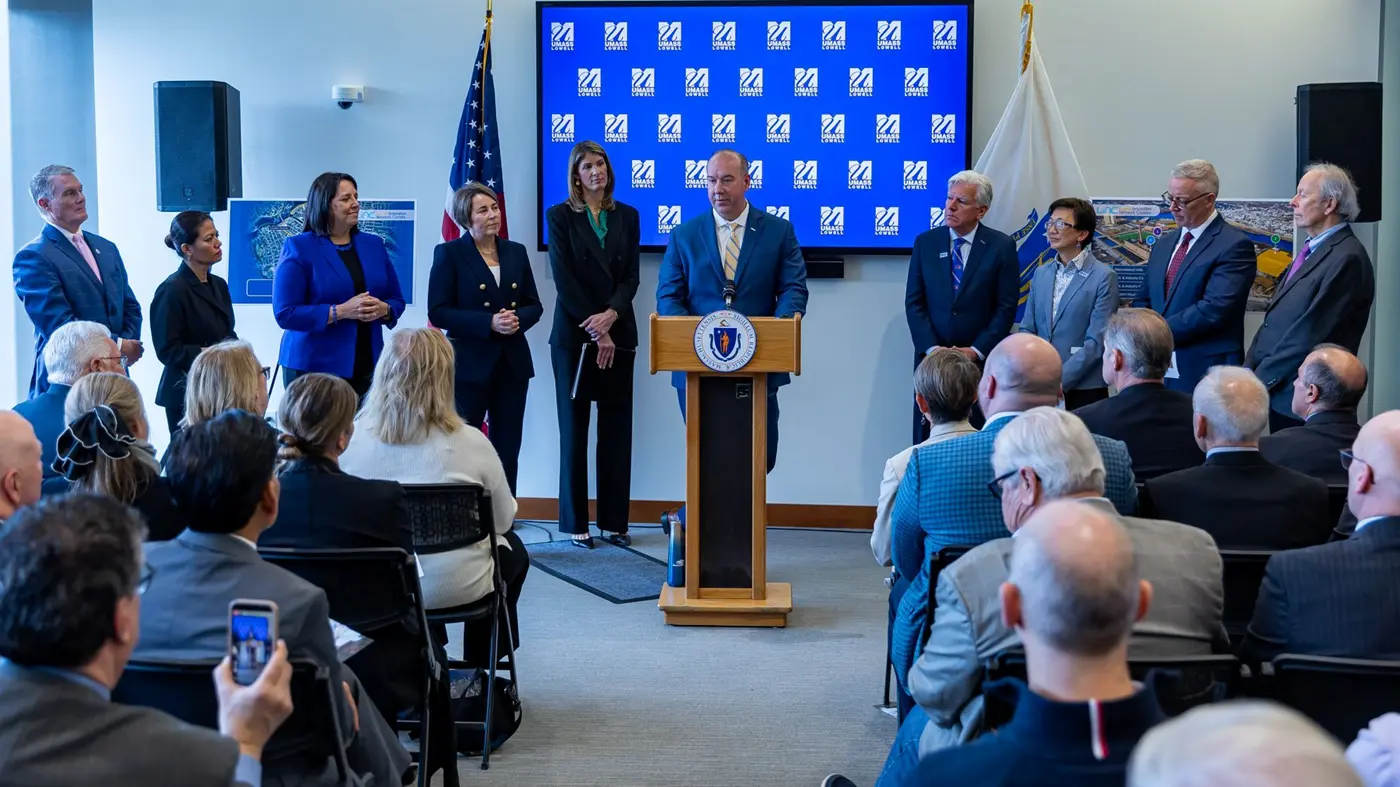 Government and university officials flank Draper chief at podium