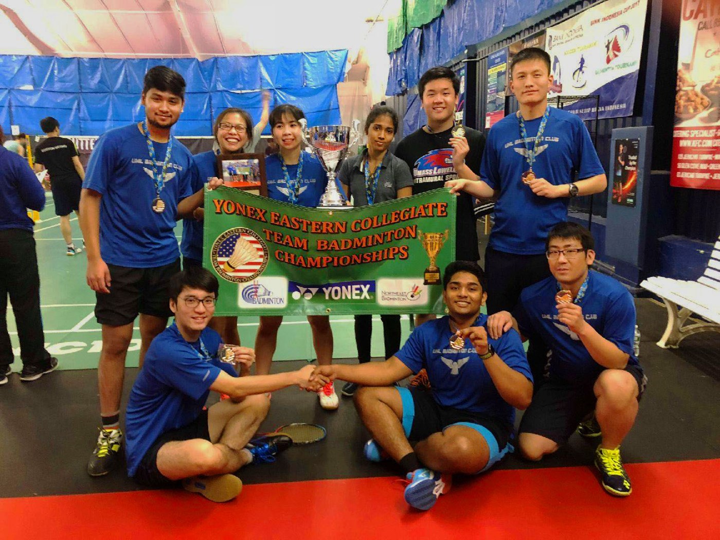 Badminton club celebrates tournament victors at indoor facility. 
