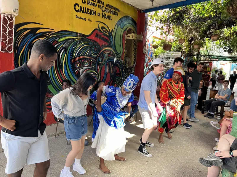 Colin Ormond dances the salsa with a group of dancers.