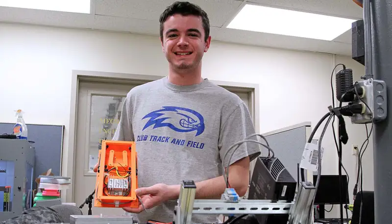 Connor Pozzi in a lab, shows his device