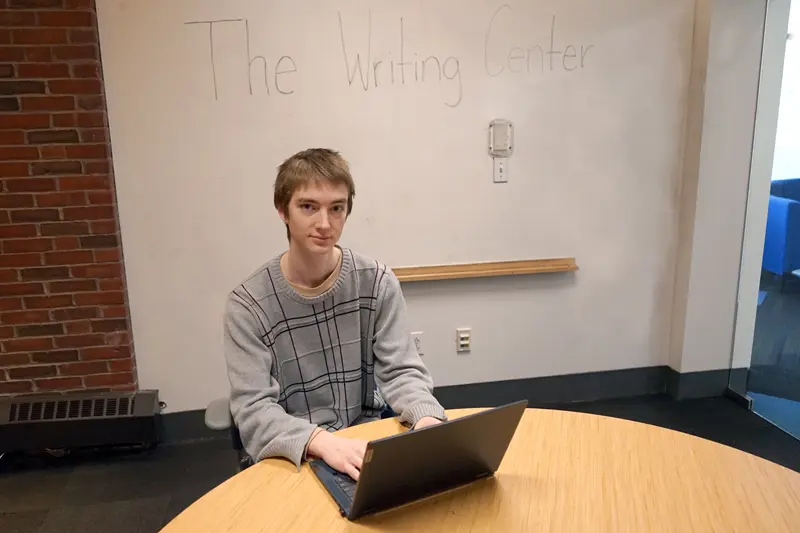 Duncan Cowie works on a laptop at The Writing Center at UMass Lowell.