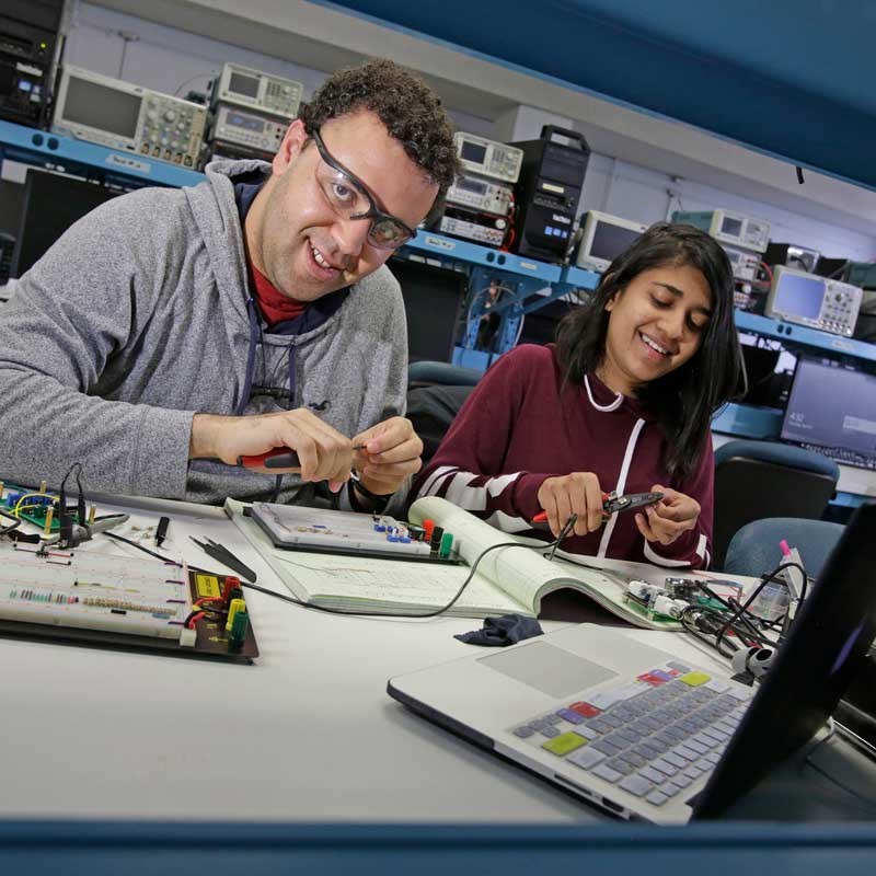 Electrical and computer engineering students cut wires in a UMass Lowell computer lab