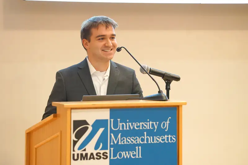 Ethan Ayotte speaks at a podium at University of Massachusetts Lowell.