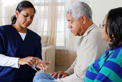 Home care worker helping elderly with medications
