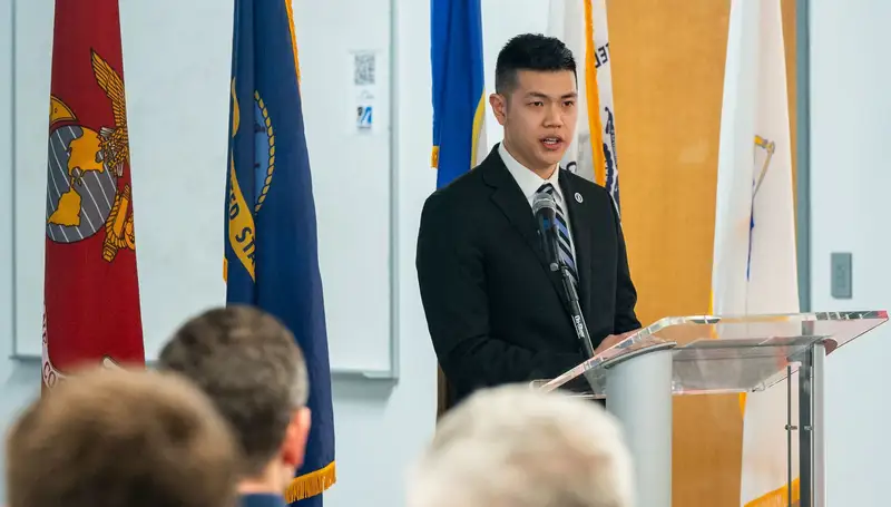 Louis Chin speaks at a lectern.