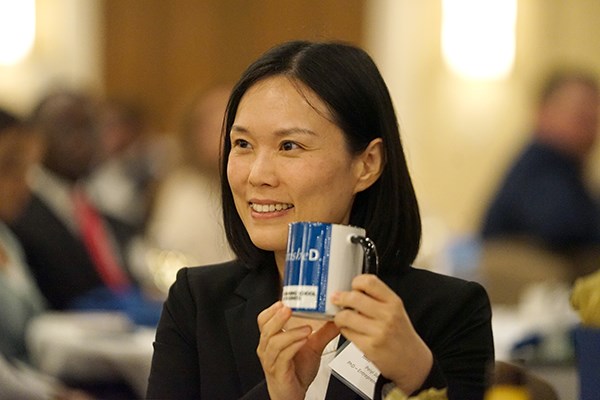 A woman poses for a photo while holding a coffee mug
