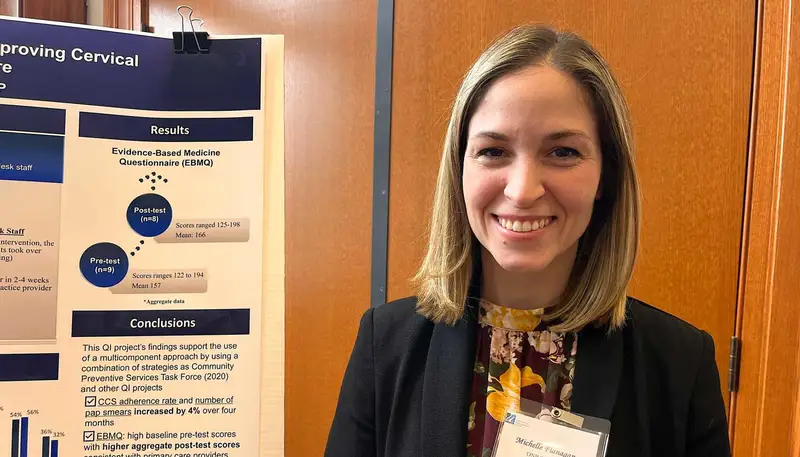 UMass Lowell DNP student Michelle Flanagan poses next to her research poster.