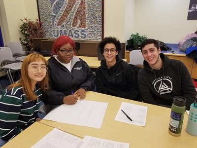 Four students work on papers at table