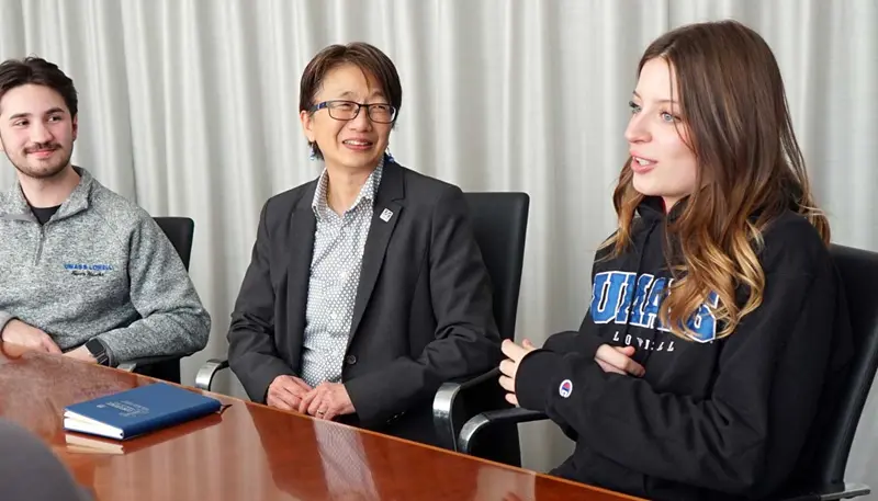 Rena McFall speaks with UMass Lowell Chancellor Julie Chen and another student.
