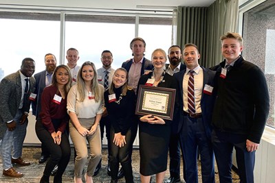 Business students pose with their winning certificate at the UMass Club