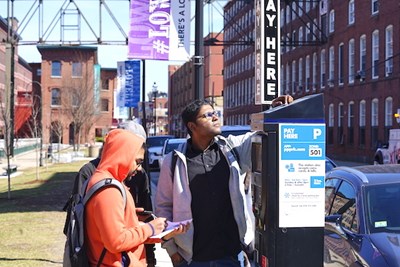 Students inspect a solar panel on a parking kiosk on Jackson Street