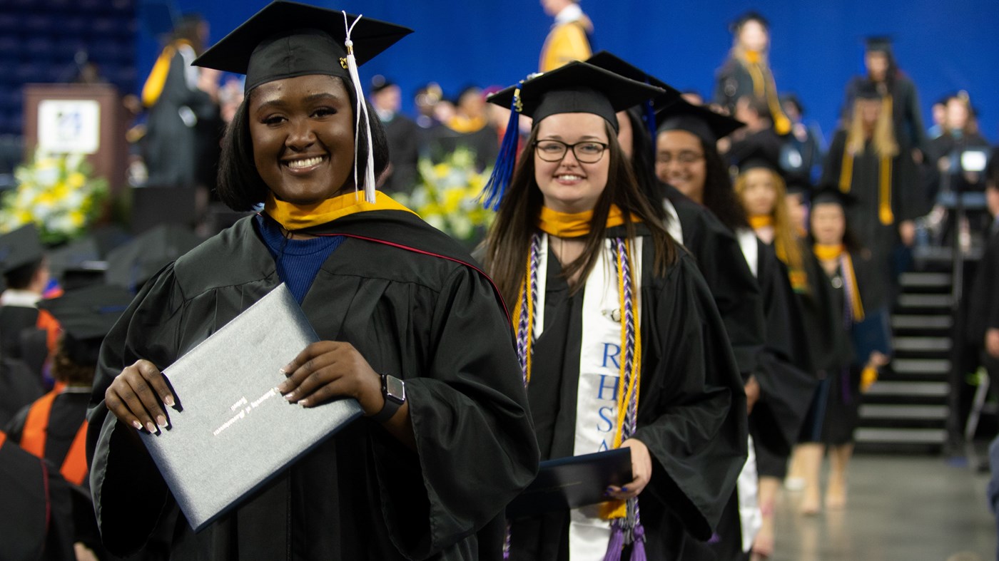 Female students process back to their seats after receiving their diplomas