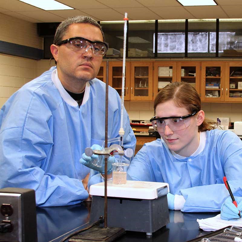 Chemistry faculty member and student heat liquid in a UMass Lowell lab