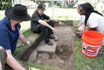 From left, Queen's University graduate student Stuart Alexander; principal surveyor Ronan McHugh of Queen's University Centre for Archaeological Fieldwork; Queen's University student Sarah Kerr; and UMass Lowell graduate student Eunice Delice excavate a trench at St. Patrick&rsquo;s Church in Lowell.