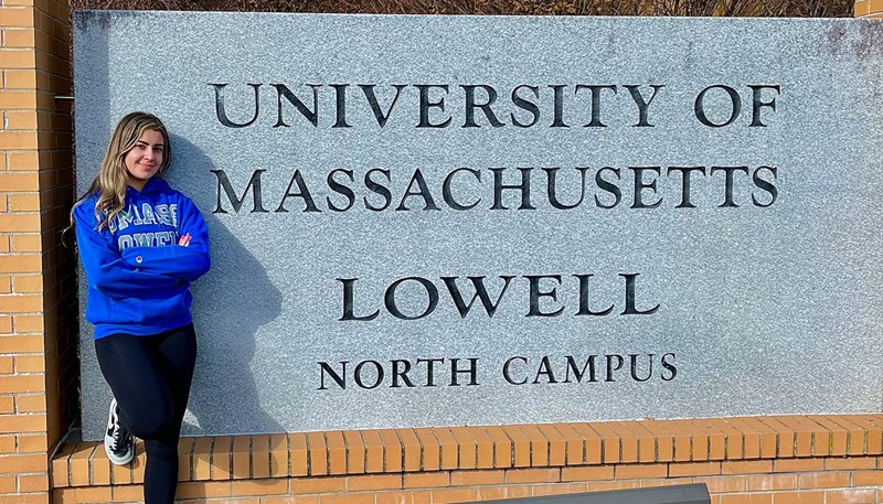 Sara is standing against the north campus sign 