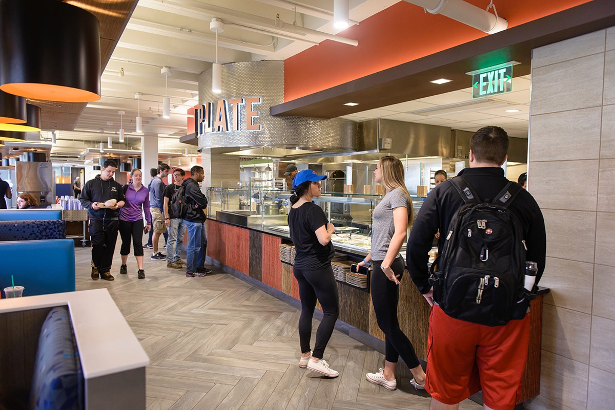 Students eating, getting food and talking at the South Campus Dining Commons in the McGauvran Center.