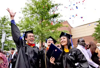 Commencement 2012 at UMass Tsongas Center, Grad Ben Nguyen (22) of Lynn, throws confetti over the heads of fellow grads Dan Brooks (26) of Gloucester and Chanthu Plauk (24) of Lowell, after leaving the Commencement. SUN/David H. Brow.