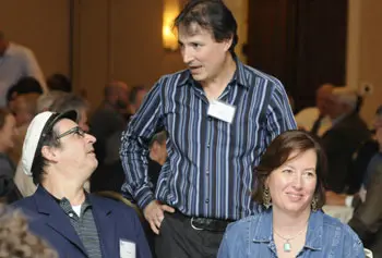 Chris Porter, center, who grew up in Lowell listening to WJUL, catches up with friends at the WUML 60th reunion dinner.