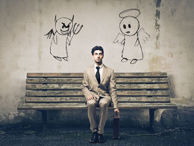 Person sitting on bench with briefcase at side and devil drawn over one shoulder, angel over other