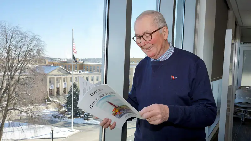 Andrew Rodger reading in front of a window.