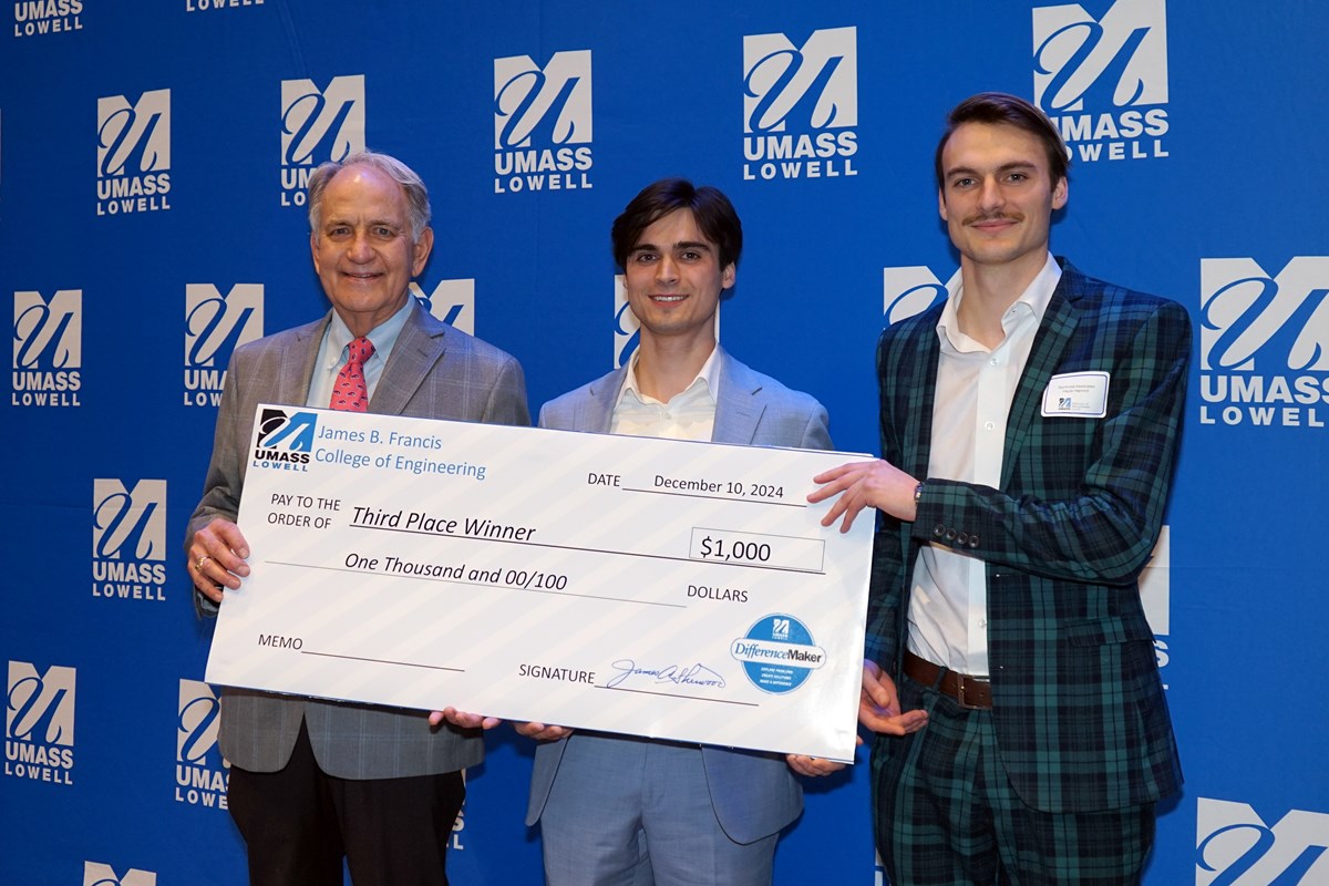 Three people pose for a photo while holding an oversized check.