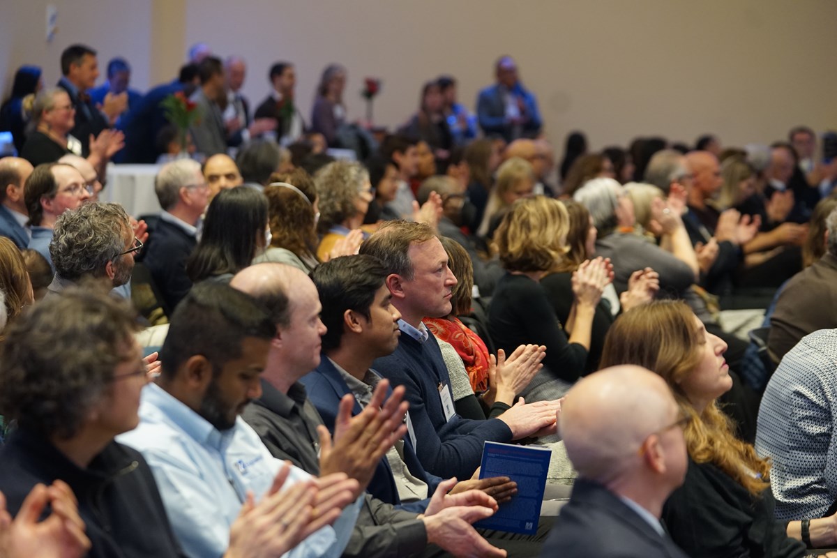 Rows of participants clapping at an award ceremony.