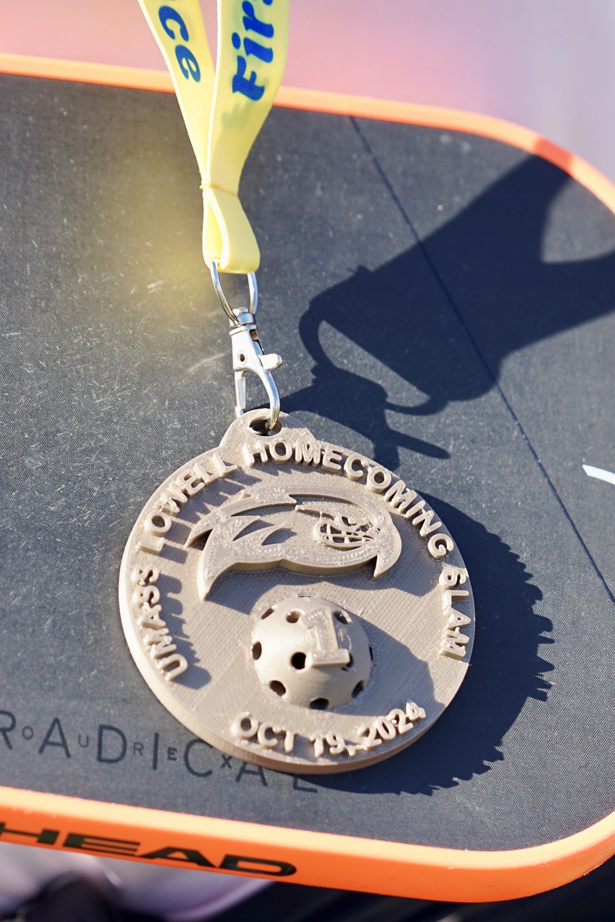 A closeup photo of a pickleball medal 3-D printed from plastic.