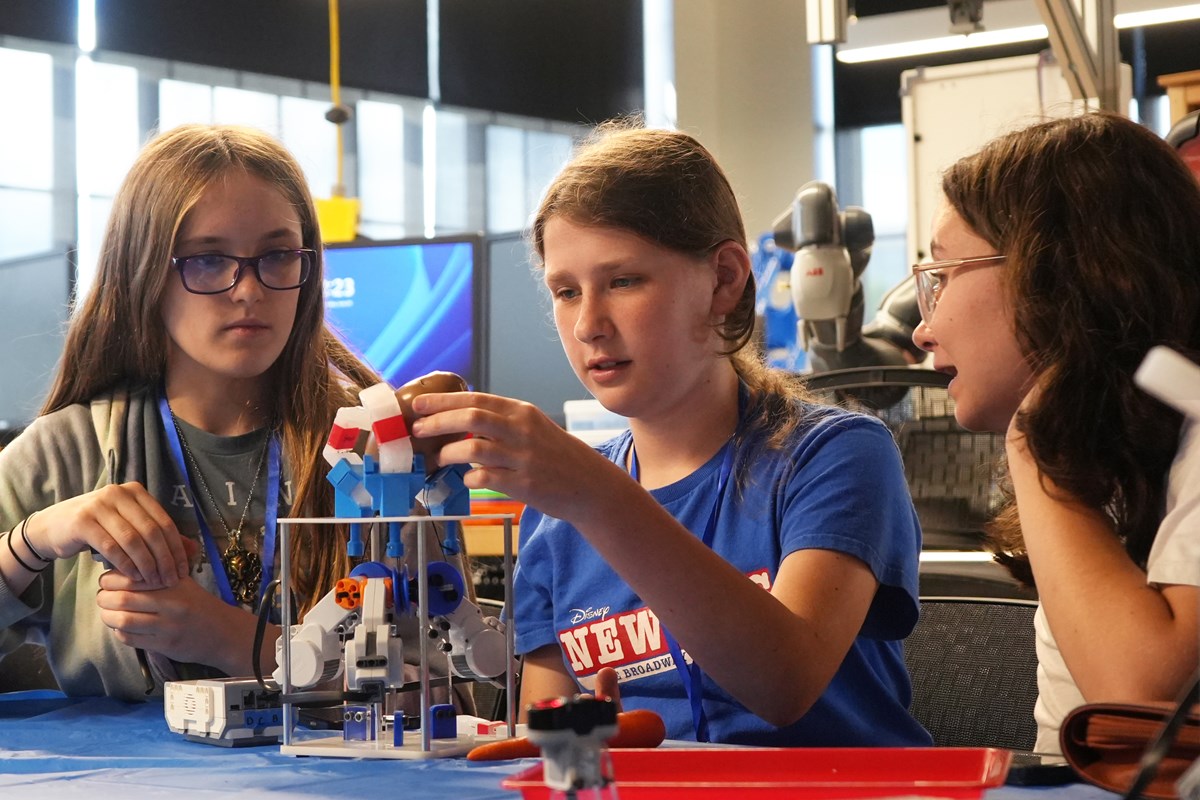 RoboXploration students Devin Francis, Bella Lomaka and Grace McGarth build a robotic structure.