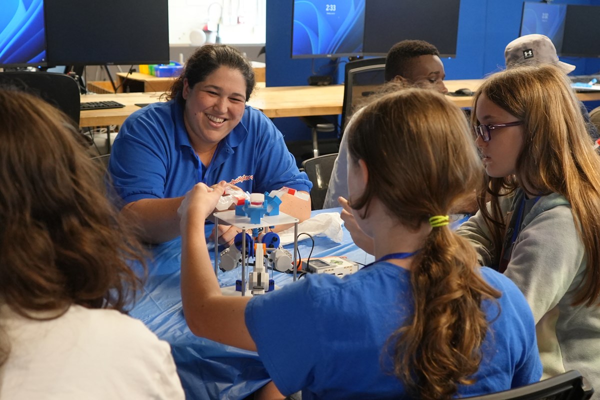 Maru Cabrera, a UMass Lowell faculty member, helps students with their robotic gripper.