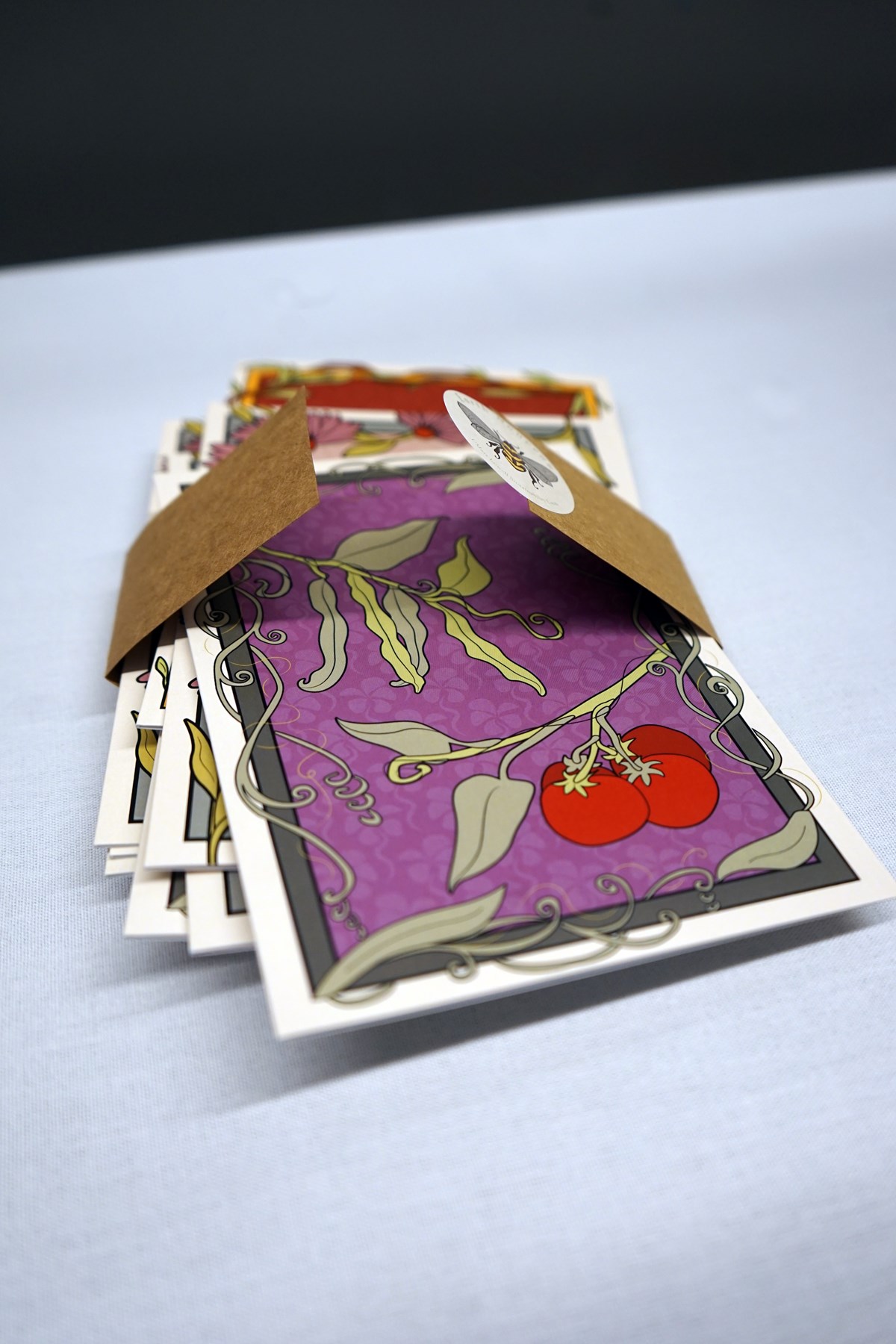 A pack of greeting cards spilling out onto a table with a white tablecloth.