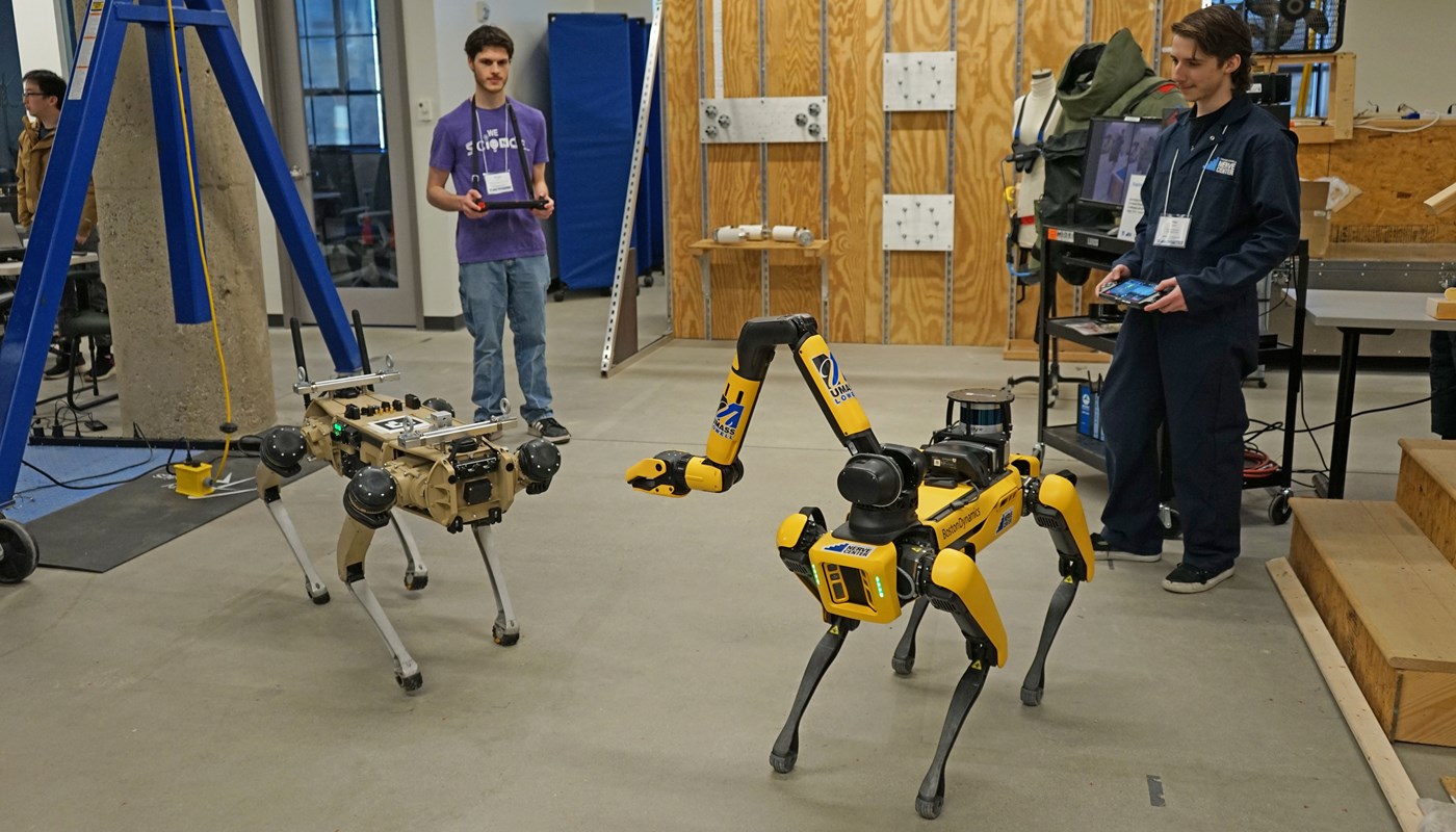 Two Computer Science students controlling dog-like robots in the NERVE center. 