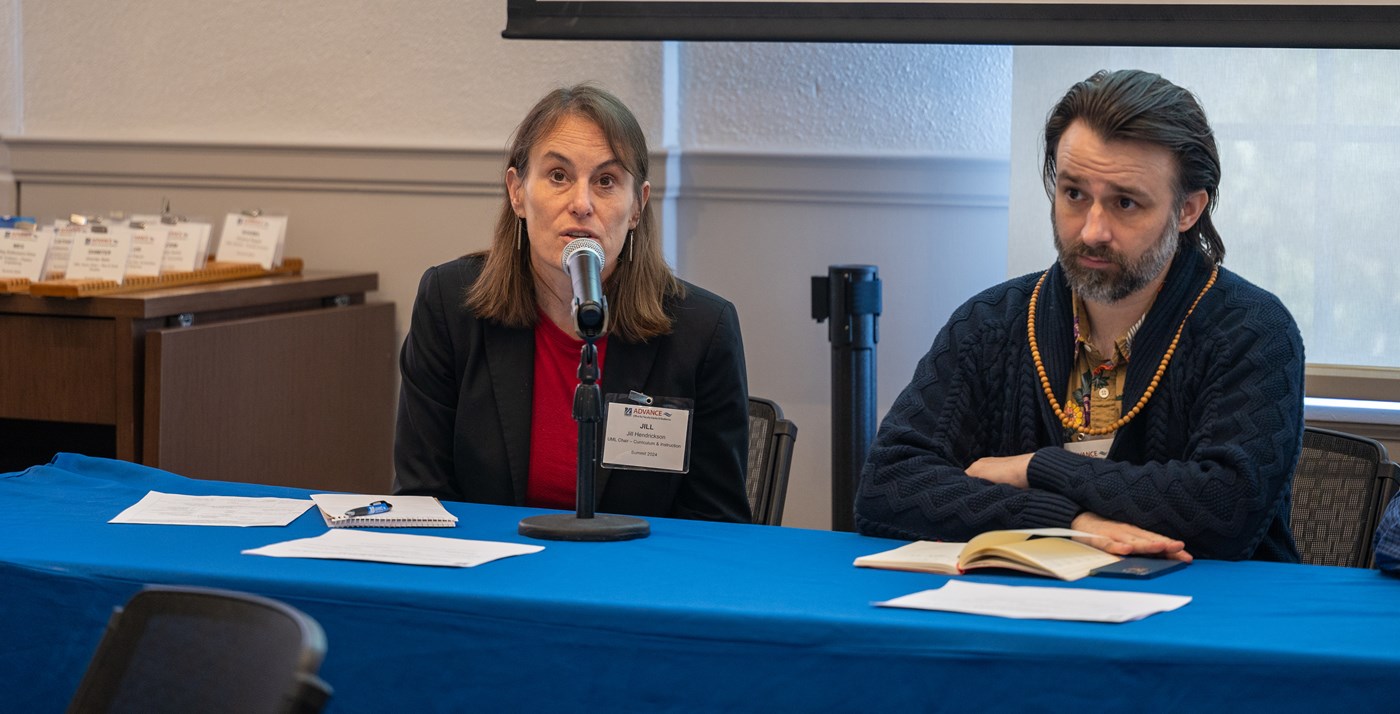 Program Evaluator for Climate Surveys sitting and talking into a microphone.