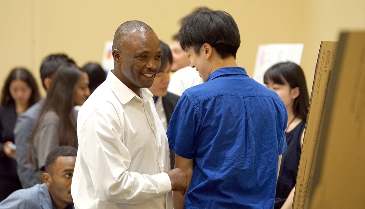 Two men speaking to each other: Students collaborate on a business project. 