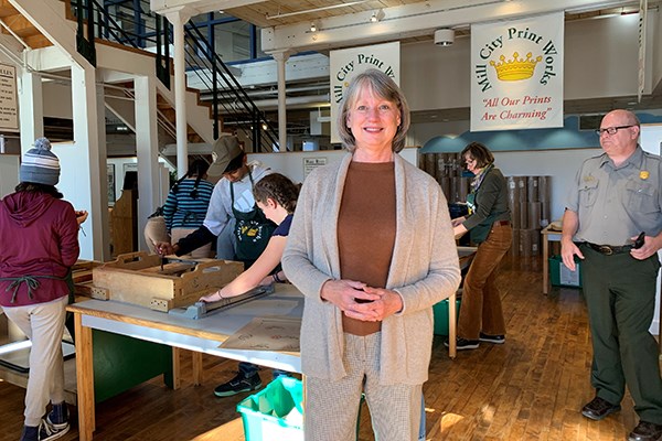 Sheila Kirschbaum stands in front of students on an assembly line at the Tsongas Industrial History Center