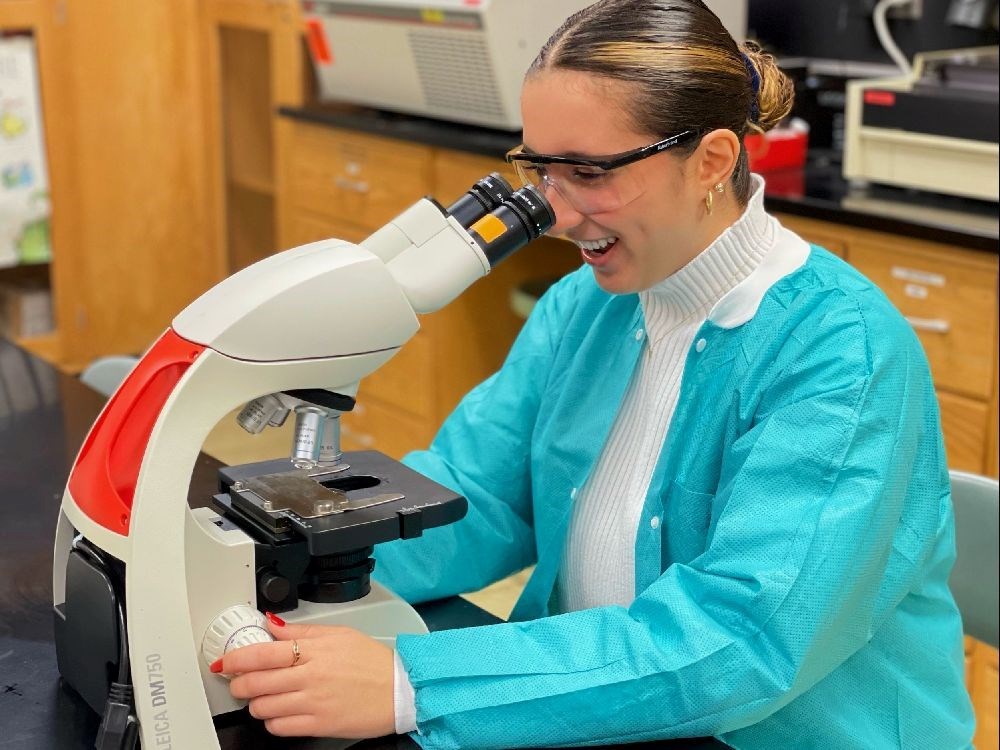 UMass Lowell student Marita Merheb looks into a microscope
