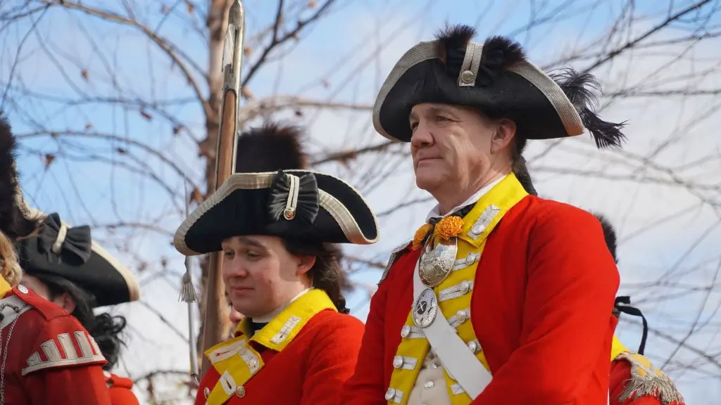 Two men are dressed as British soldiers outside.