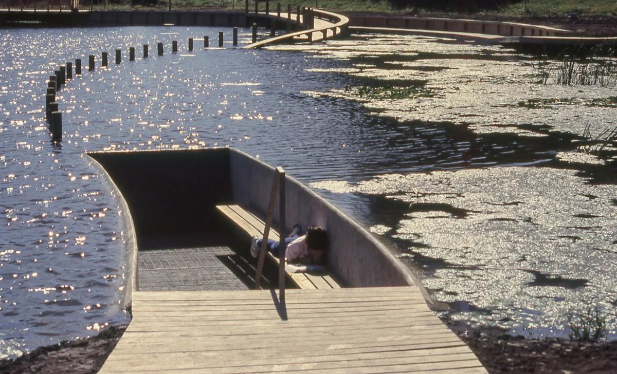 Wooden walkway and bench over waterway