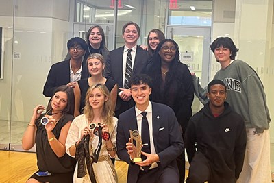 A hand holds up a first-place award for the Bryant College Mock Trial tournament