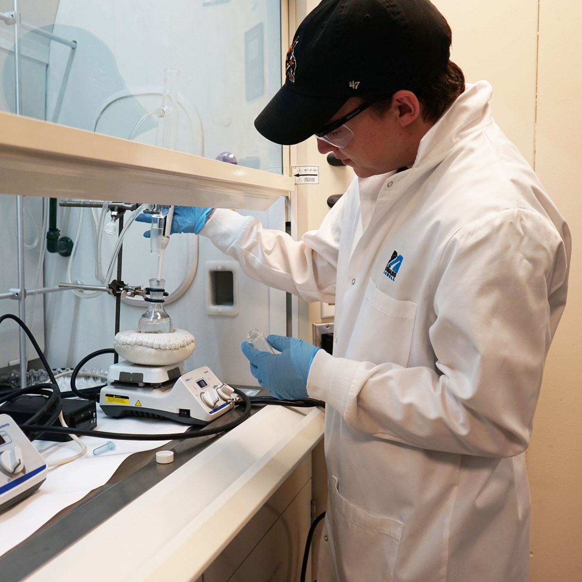 Chemistry student, Noah Mason, using a pipette in a lab. 