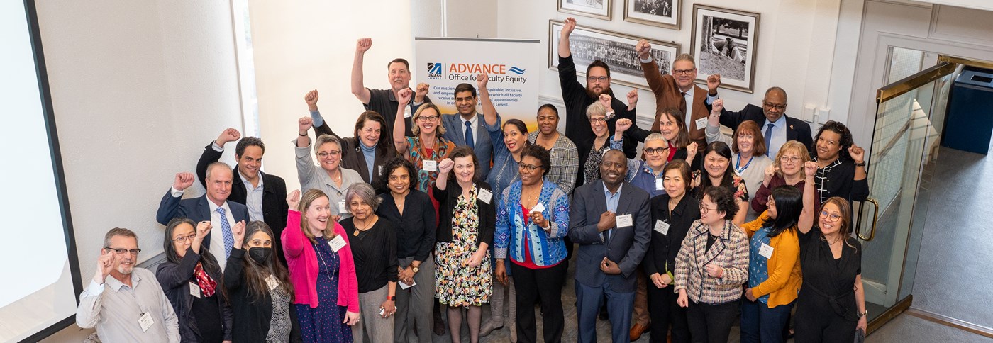 Group of people celebrating Summit success with hands raised.