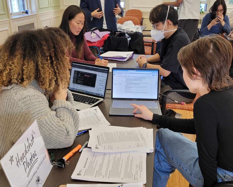 A group of students getting tutor how to fix their resume.