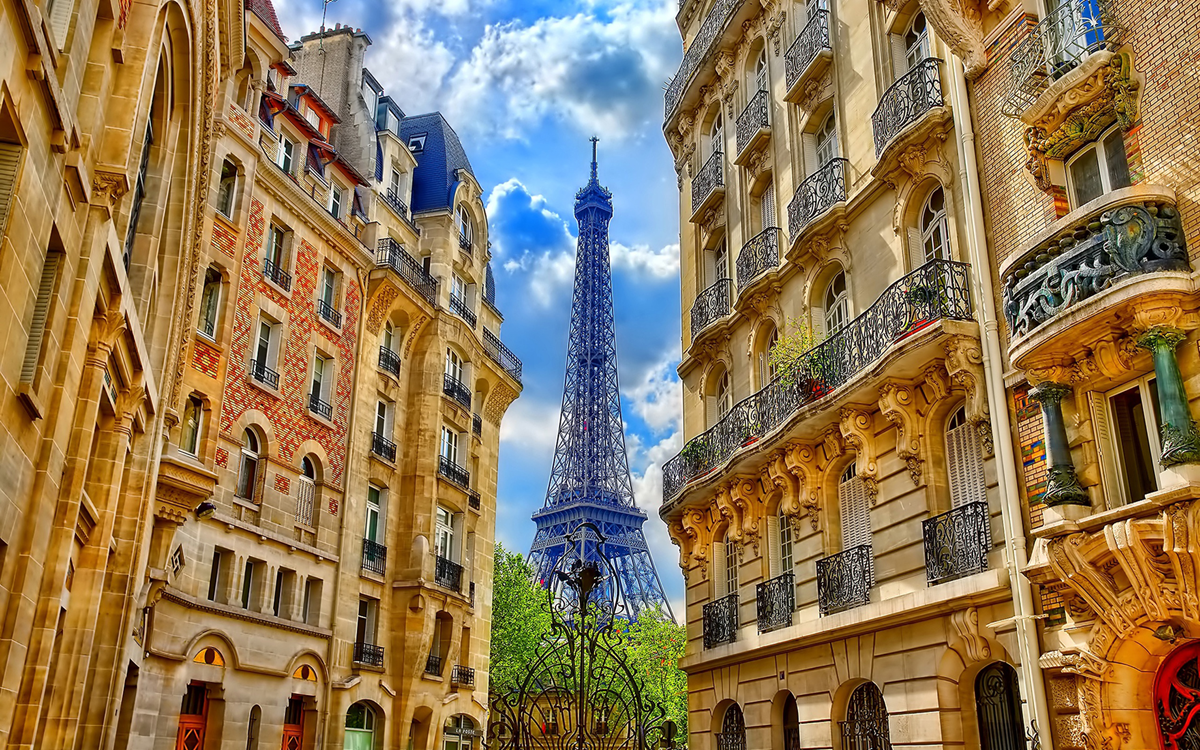 View of Eiffel Tower Paris between two beige colored buildings.