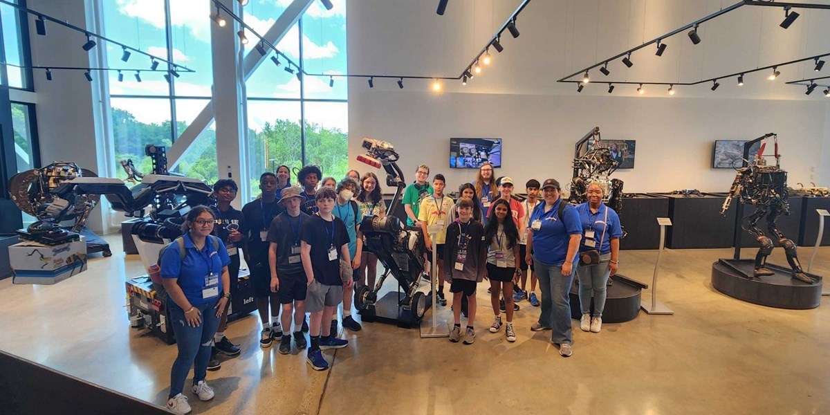 RoboXploration program leaders and students pose in the offices of Boston Dynamics.
