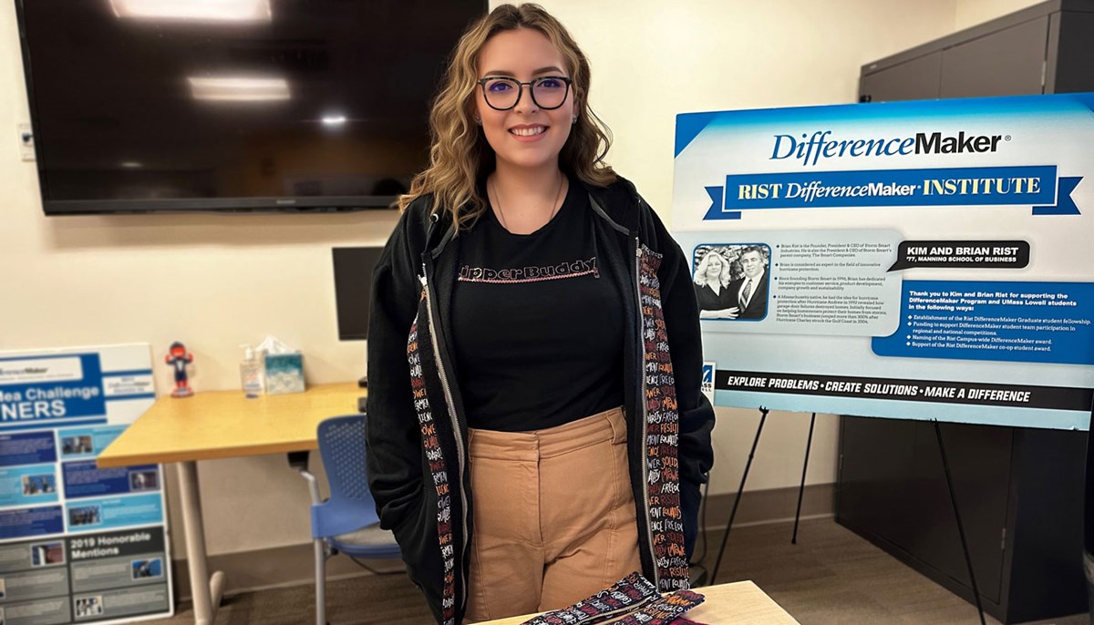 UMass student Sandi DeRuntz stands in front of Difference Maker sign.