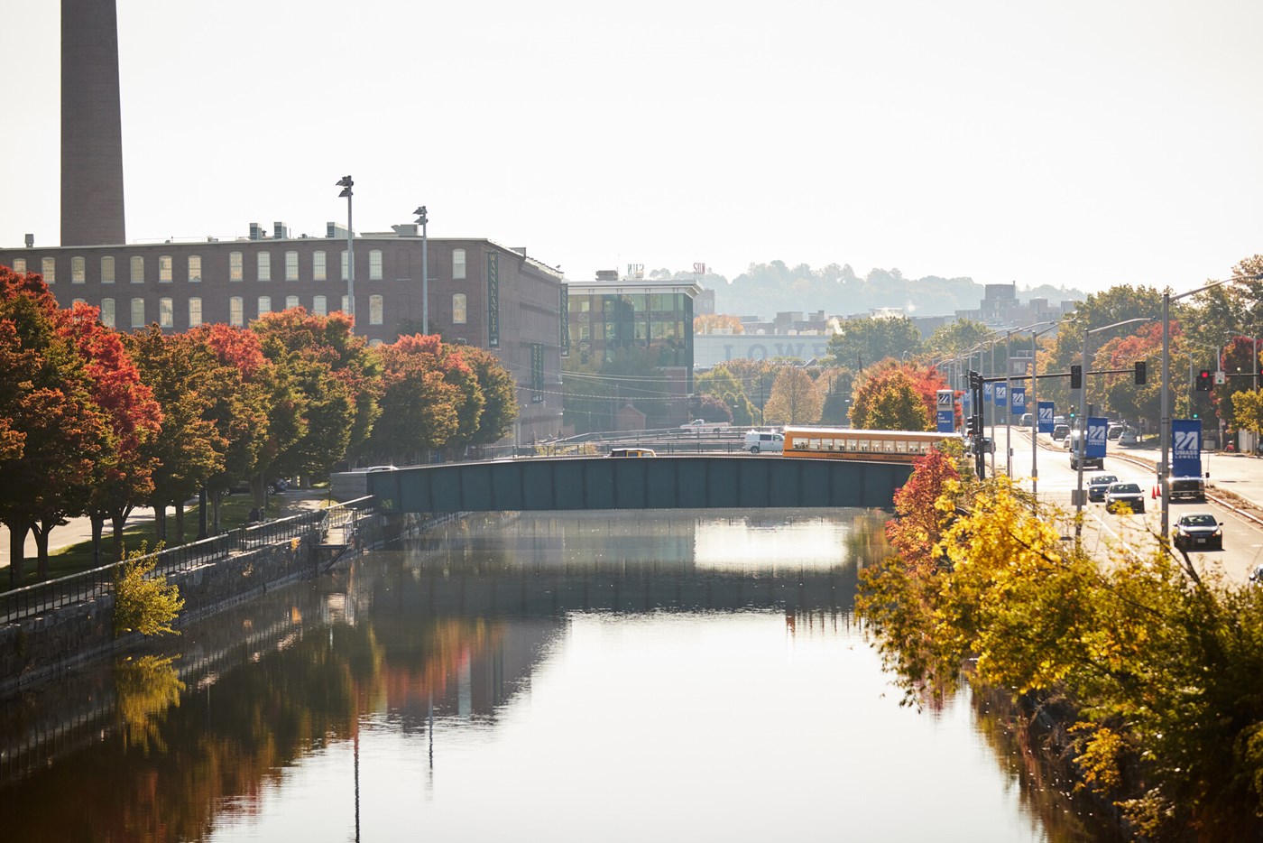 Trees emblazoned in fall foliage flank a canal on Lowell's East Campus