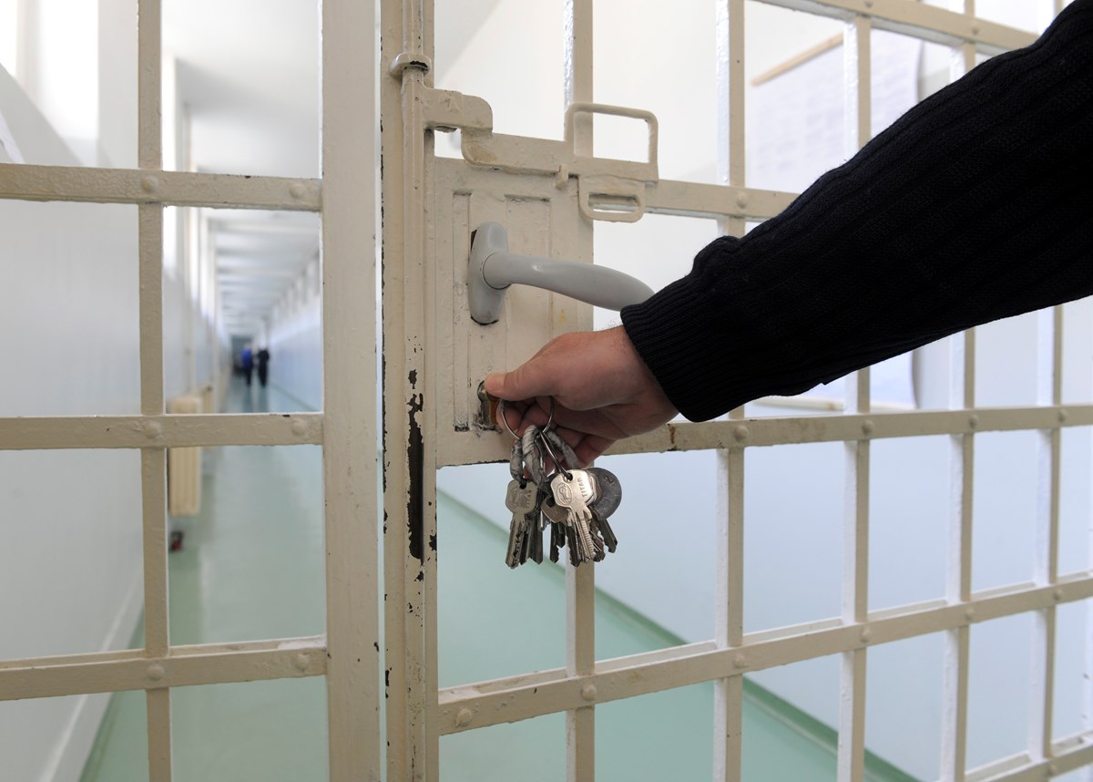 Close up of a hand of a corrections officer locking a cell door