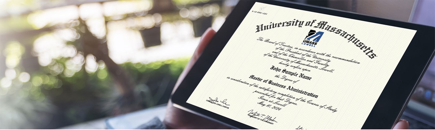 Hands holding the UMass Lowell diploma.