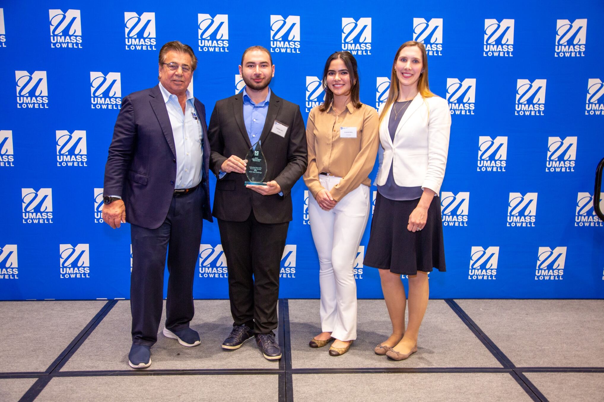 Team EV Guardian posing for a picture with Brian Rist and Holly Lalos after receiving an award.