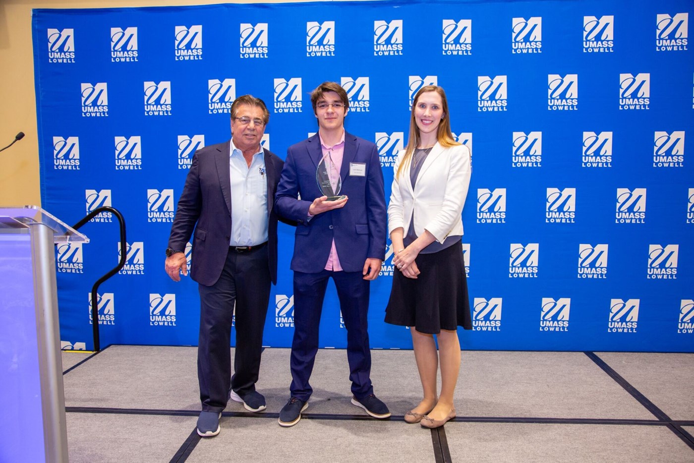 Team Next Gen Testing posing for a picture with Brian Rist and Holly Lalos after receiving an award.