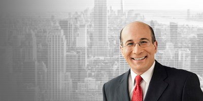 Headshot of Ron Insana, senior business analyst and commentator on CNBC, on gray cityscape background